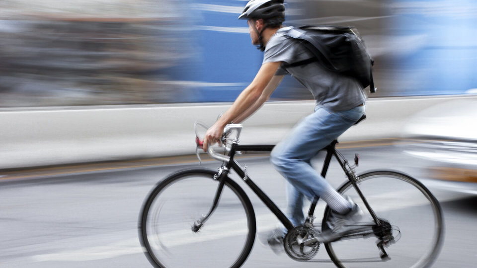 Man riding bike fast in middle of road