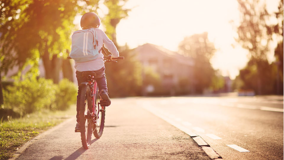 Newsroom - child on bicycle on pavement