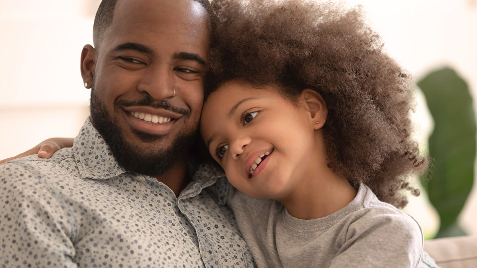 Father with young daughter smiling